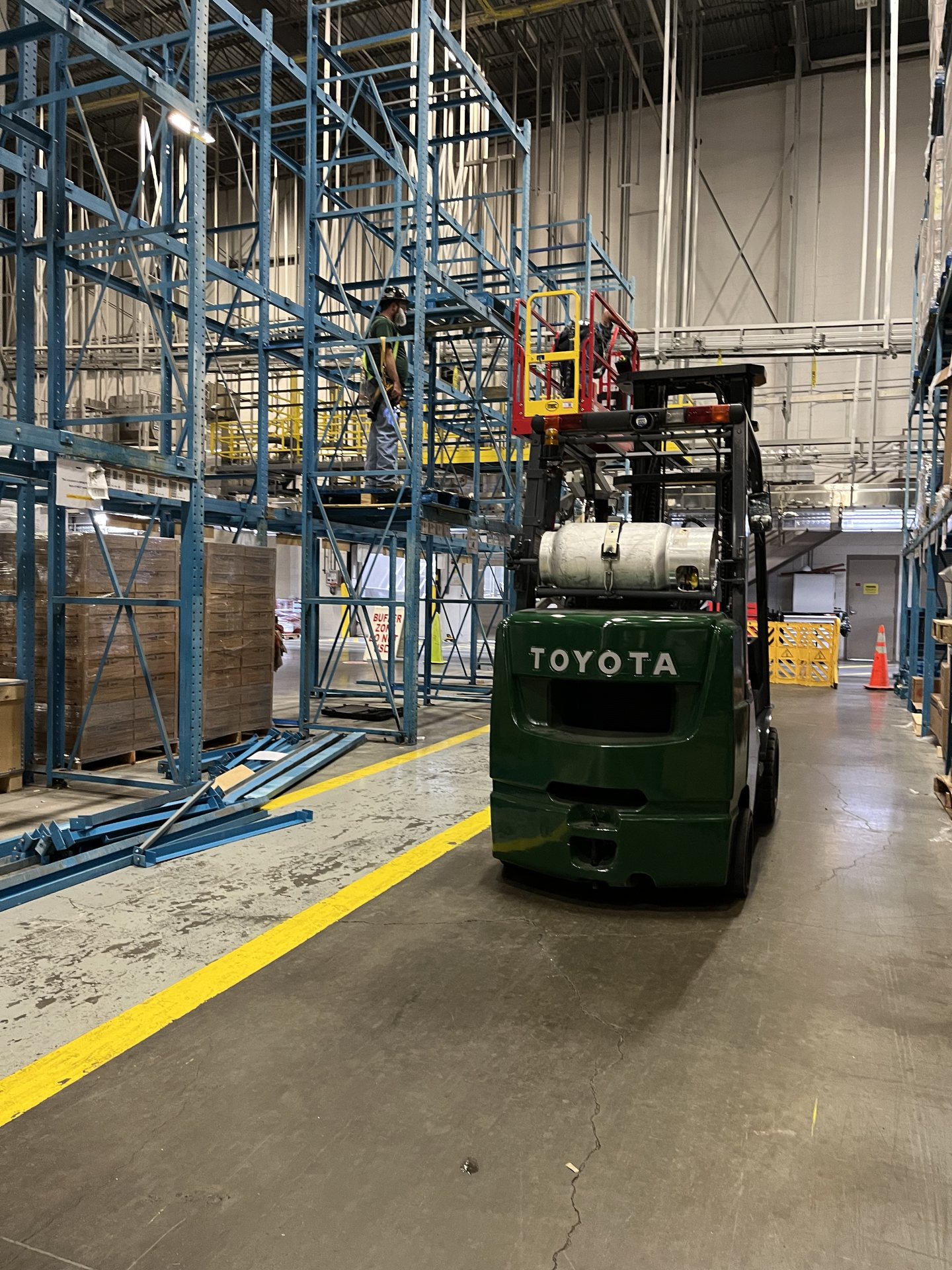 Crew installing warehouse pallet racking with a forklift and boom lift in Virginia