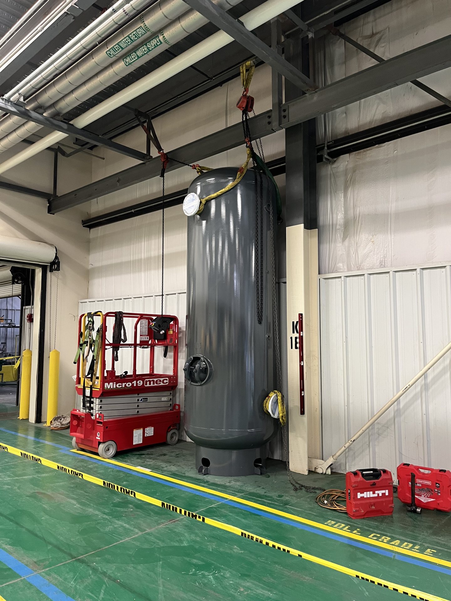 Pressure vessel rigged on chains and slings inside a mechanical room in Virginia